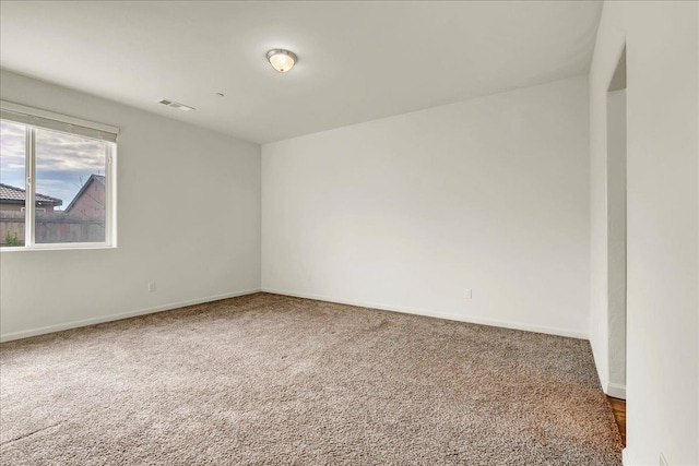 empty room with visible vents, baseboards, and carpet floors