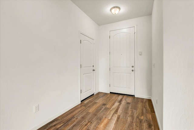 entryway with dark wood finished floors and baseboards