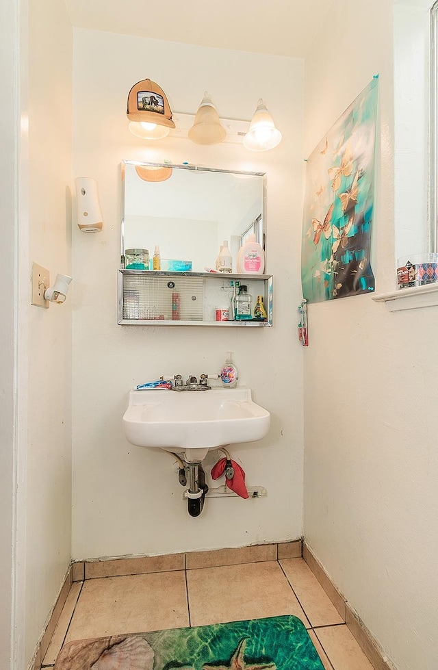 bathroom with tile patterned flooring, baseboards, and a sink