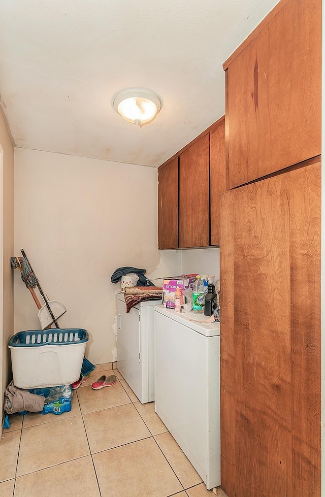 washroom with washer and dryer, light tile patterned flooring, and cabinet space