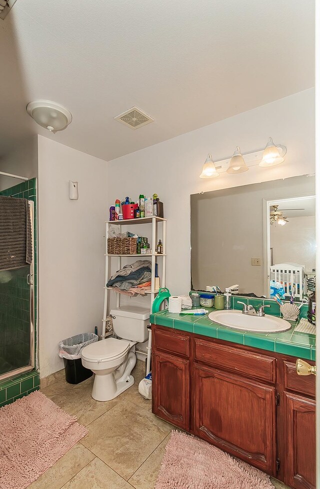 bathroom featuring visible vents, a stall shower, toilet, and vanity