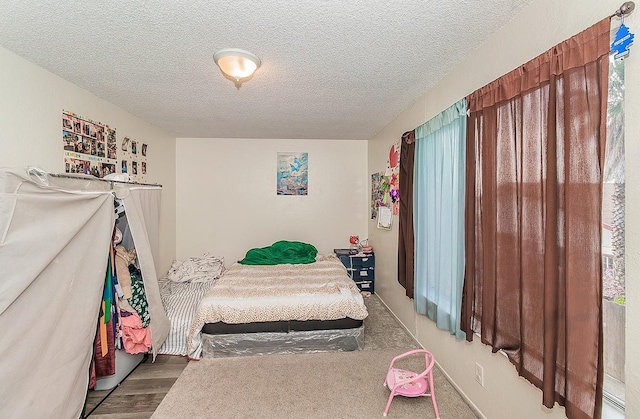 bedroom with wood finished floors and a textured ceiling