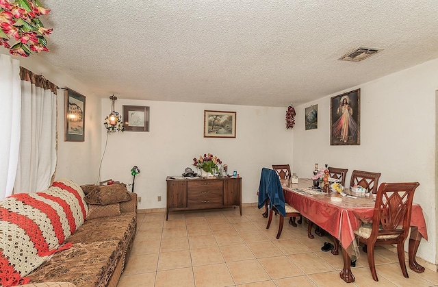 dining space with light tile patterned floors, visible vents, and a textured ceiling