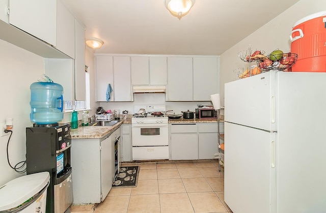 kitchen featuring white appliances, light tile patterned floors, light countertops, under cabinet range hood, and white cabinetry