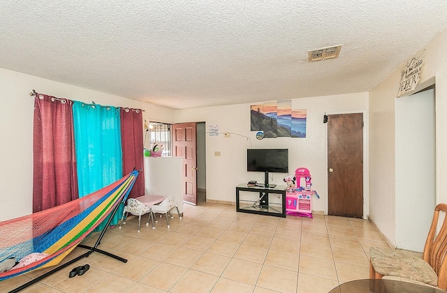 rec room with light tile patterned floors, visible vents, and a textured ceiling