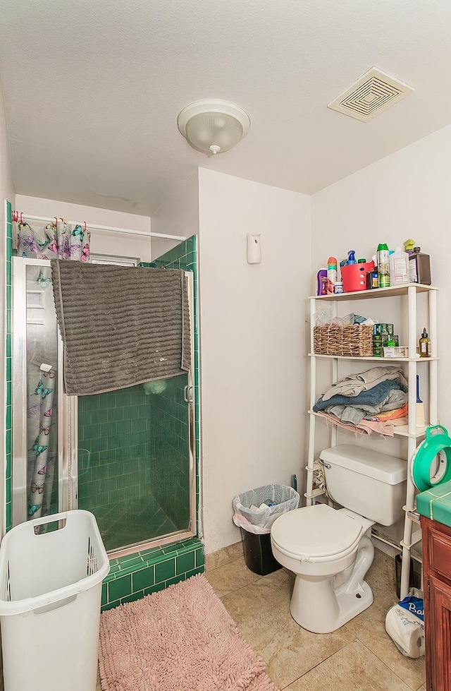 full bath featuring tile patterned floors, toilet, visible vents, and a stall shower