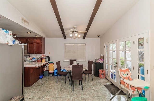 dining room with vaulted ceiling with beams, visible vents, light tile patterned floors, and ceiling fan