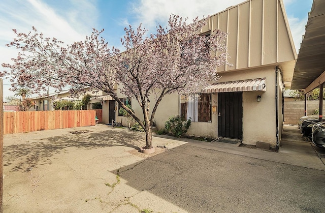 view of front of property featuring fence and stucco siding