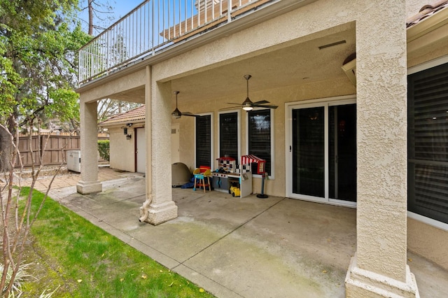 view of patio / terrace with a balcony, ceiling fan, and fence