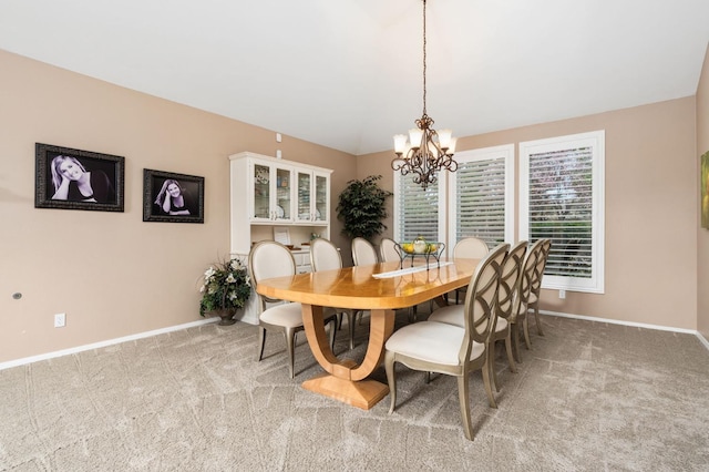 dining area with baseboards, light carpet, and a notable chandelier