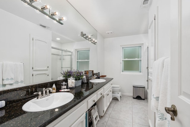 bathroom featuring tile patterned flooring, a stall shower, visible vents, and a sink