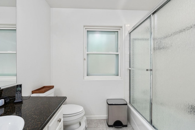 bathroom with tile patterned floors, toilet, vanity, and shower / bath combination with glass door