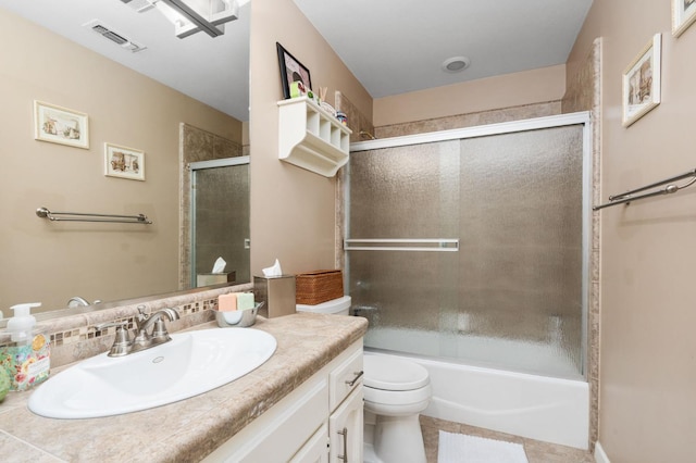 full bath with tile patterned floors, visible vents, toilet, bath / shower combo with glass door, and vanity