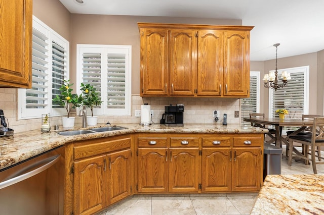 kitchen featuring backsplash, light stone countertops, stainless steel dishwasher, brown cabinetry, and a sink