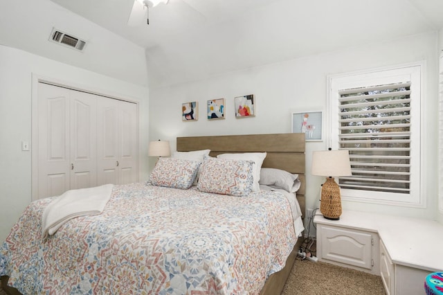 bedroom with visible vents, a ceiling fan, a closet, lofted ceiling, and light colored carpet