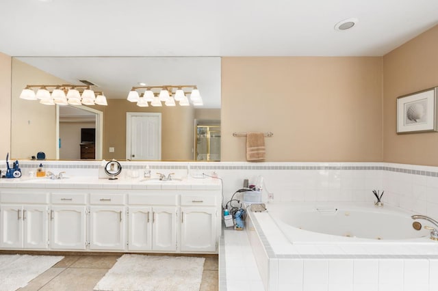 full bath featuring double vanity, a stall shower, a whirlpool tub, a sink, and tile patterned floors