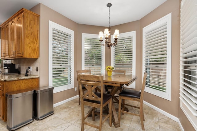 dining area with baseboards, a notable chandelier, and light tile patterned flooring