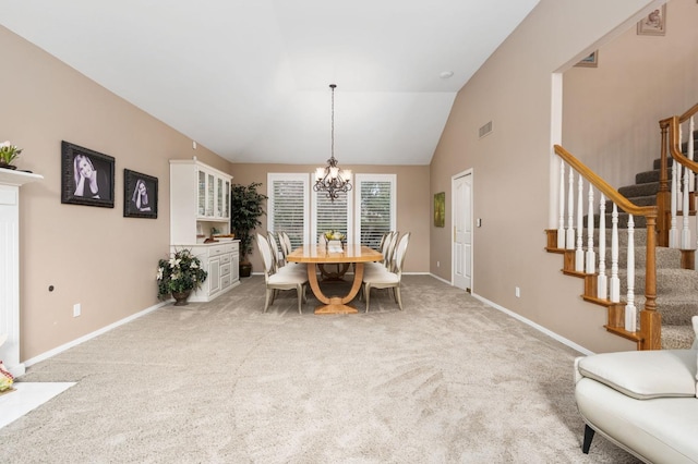 dining area with visible vents, a notable chandelier, light colored carpet, stairs, and vaulted ceiling