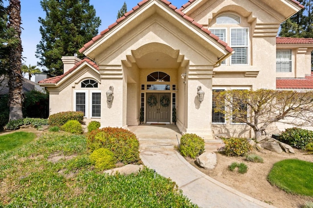 property entrance featuring stucco siding and a tiled roof