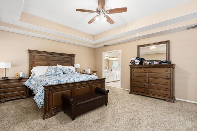 bedroom featuring visible vents, light carpet, a ceiling fan, a tray ceiling, and baseboards