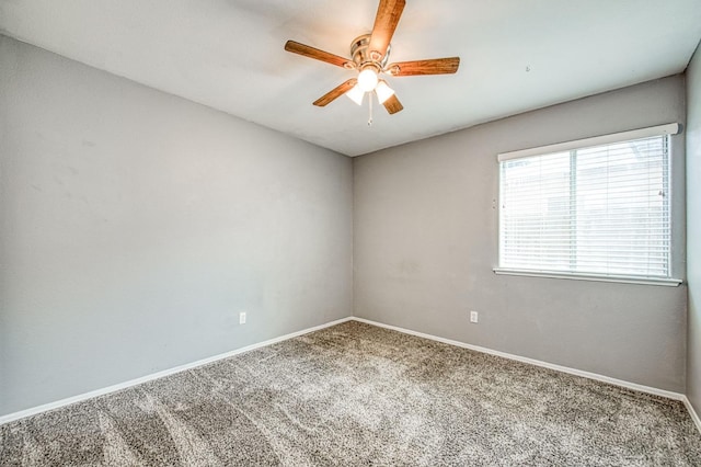 carpeted empty room with a ceiling fan and baseboards