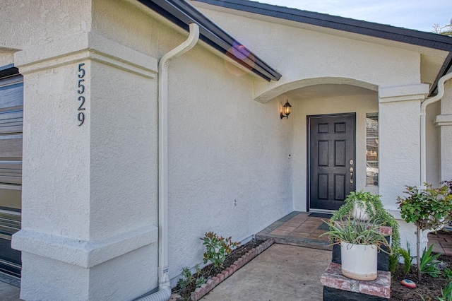 view of exterior entry with stucco siding