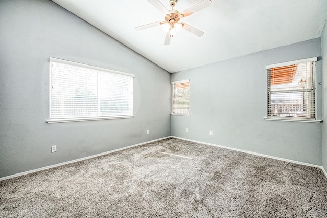 carpeted empty room featuring vaulted ceiling, a ceiling fan, and baseboards