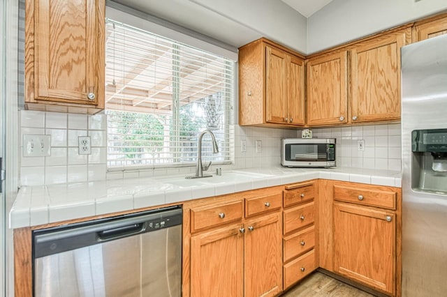 kitchen featuring a sink, stainless steel appliances, and tasteful backsplash