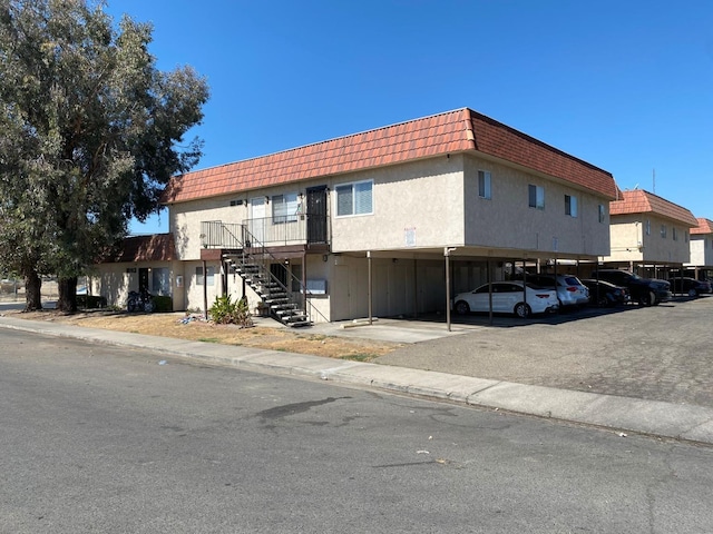 view of property featuring stairway and covered parking