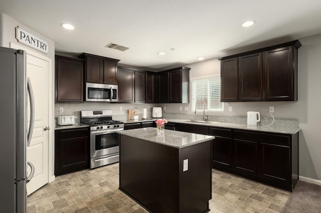 kitchen with stone finish floor, visible vents, appliances with stainless steel finishes, and a sink