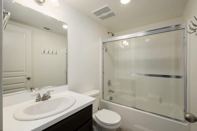 full bath with visible vents, enclosed tub / shower combo, toilet, and vanity