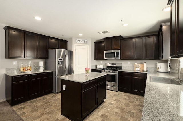 kitchen featuring light stone counters, recessed lighting, visible vents, and stainless steel appliances