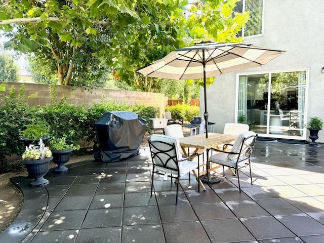 view of patio / terrace featuring a grill, outdoor dining space, and fence