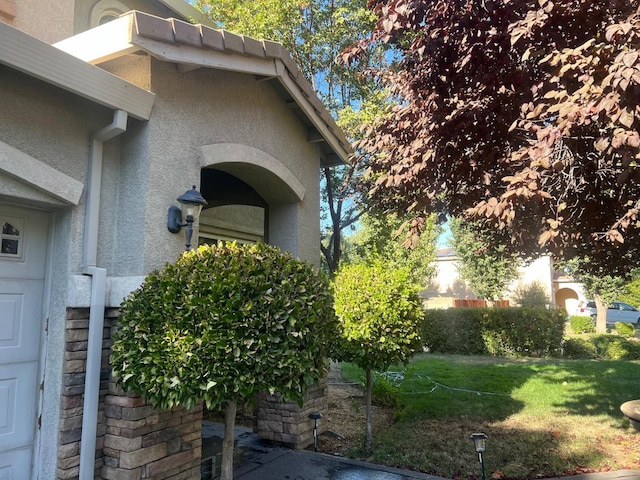 view of property exterior featuring a lawn and stucco siding