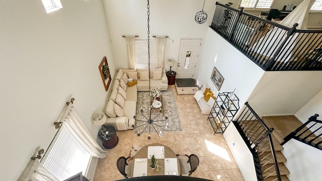 living room with stairs, tile patterned floors, and a towering ceiling