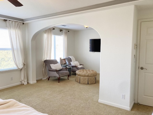 living area with arched walkways, carpet flooring, and a healthy amount of sunlight