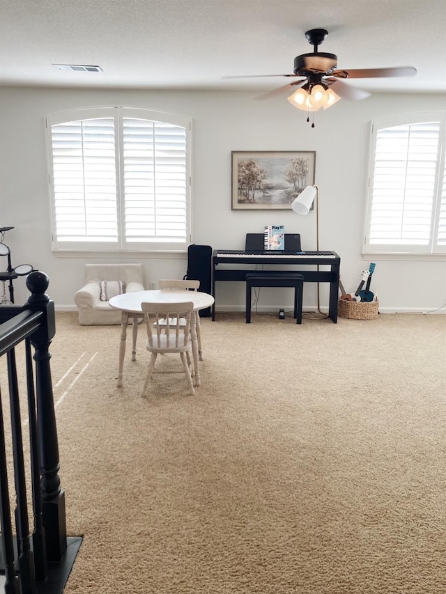 interior space featuring baseboards, visible vents, a wealth of natural light, and ceiling fan