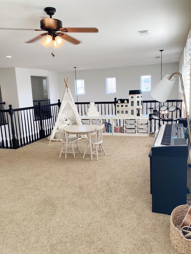 playroom with carpet, visible vents, and ceiling fan