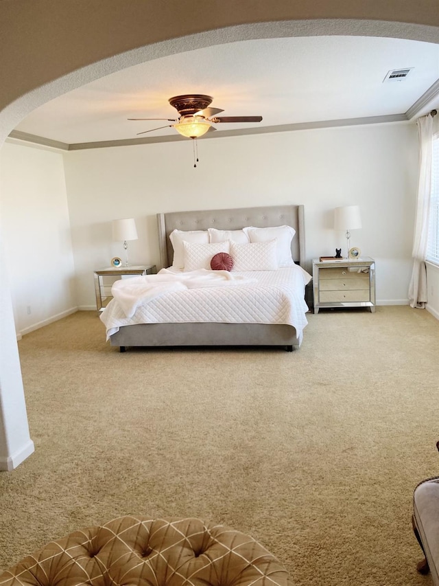 bedroom with a ceiling fan, carpet, visible vents, and arched walkways