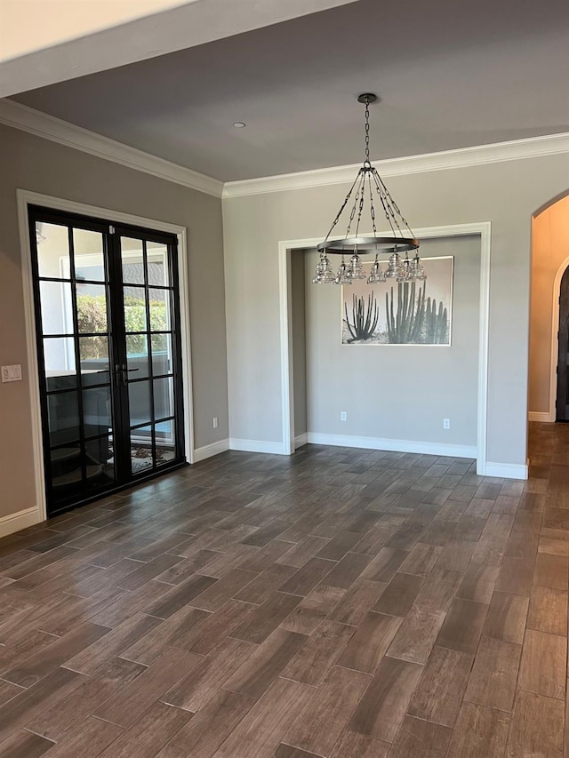 empty room featuring baseboards, ornamental molding, french doors, arched walkways, and dark wood-style flooring