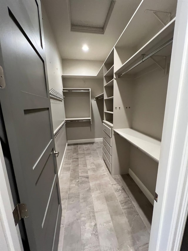 walk in closet featuring attic access