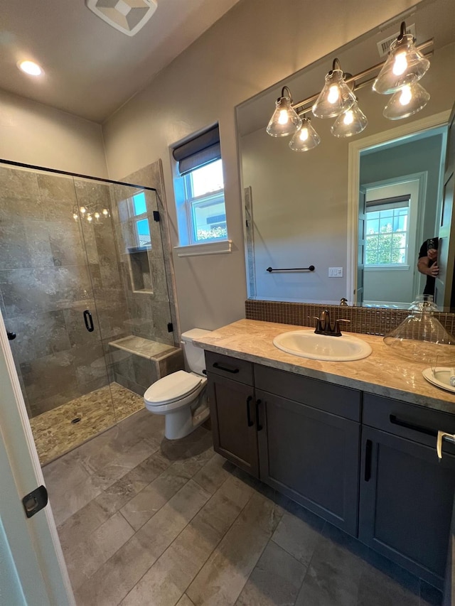 full bathroom with a shower stall, toilet, double vanity, and a sink