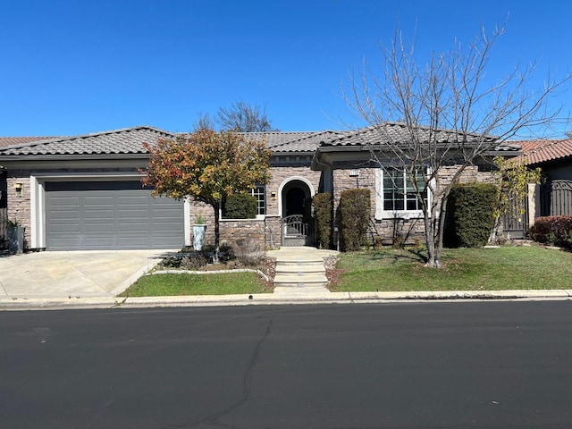 view of front of property with driveway, a front lawn, stone siding, a garage, and a tile roof