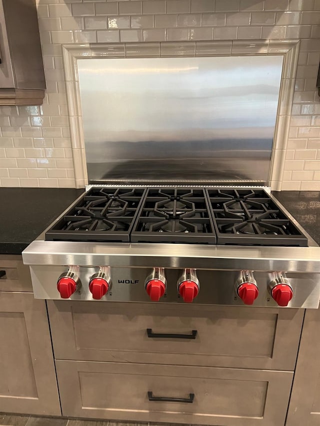 kitchen with decorative backsplash, dark countertops, and stainless steel gas cooktop