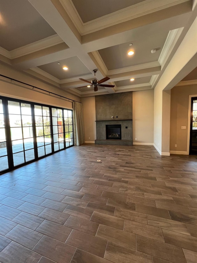 unfurnished living room featuring baseboards, a large fireplace, beam ceiling, and wood tiled floor