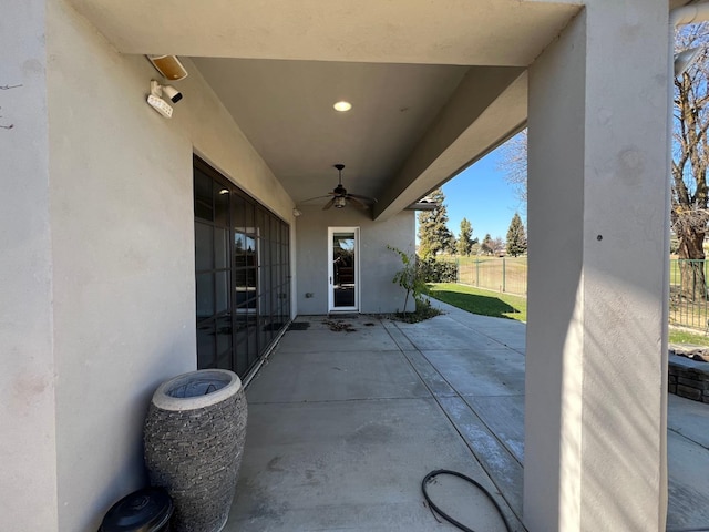 view of patio featuring a ceiling fan and fence