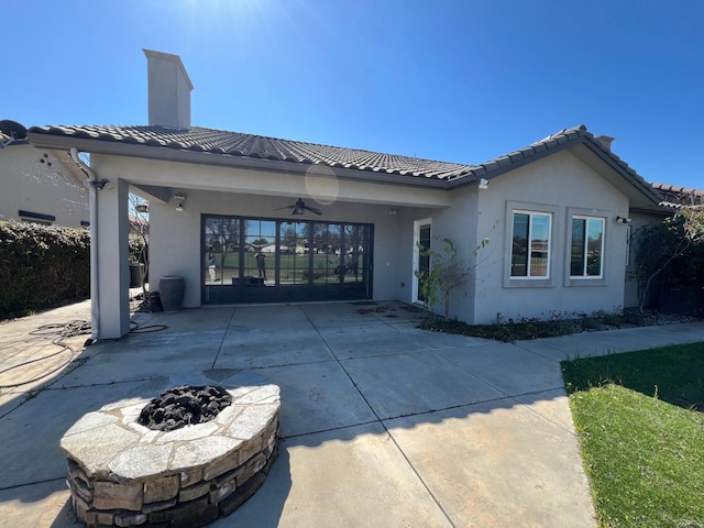 view of front of property with stucco siding, a patio area, concrete driveway, and an outdoor fire pit