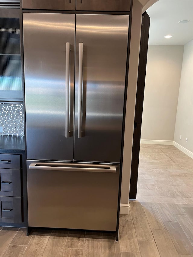 room details featuring arched walkways, wood finish floors, baseboards, and built in fridge