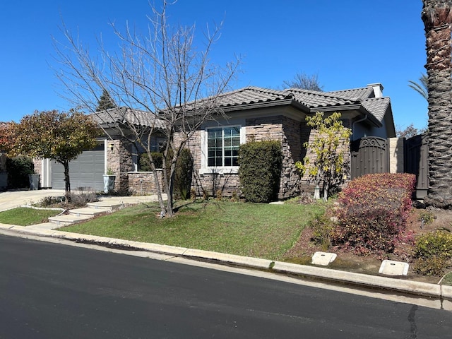 view of front of home featuring driveway, a gate, a tile roof, stone siding, and a garage