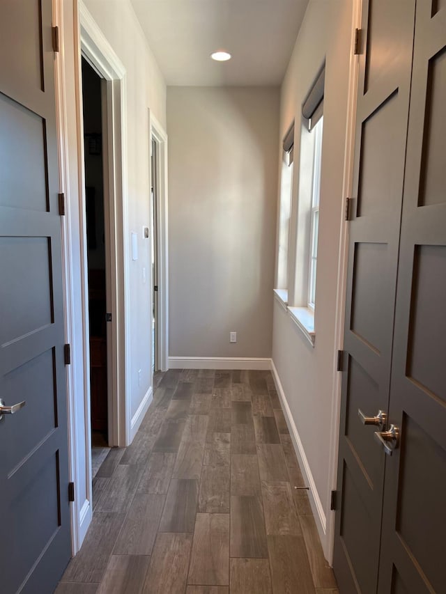 hallway with dark wood-style floors, recessed lighting, and baseboards